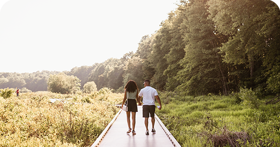 Couple strolling down walkway surrounded by lush greens